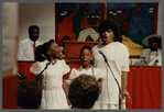 Two girls and woman in white singing at Central Holiness Church of God