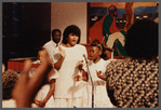 Two girls and woman in white singing at Central Holiness Church of God