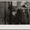Men talking in front of saloon on lower Douglas Street, Omaha, Nebraska.