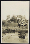 George Arliss with his dog  sitting at the edge of a water feature in a garden