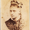 Oval portrait of unidentified young woman with long curl draped over chest. 'Redd' on verso.