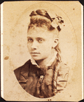 Oval portrait of unidentified young woman with long curl draped over chest. 'Redd' on verso.
