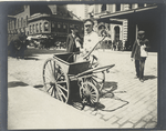 Street sweeper with hand cart.