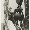 A worker riding on a crane hook
