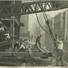 Workers guiding hoisting cable