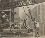 Workers guiding hoisting cable