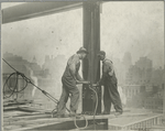 Two workers securing a rivet