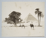 Two men riding camels in front of a pyramid