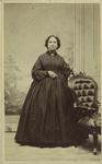 Woman standing next to chair, United States, 1860s