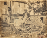 Boy pulling another boy in a wheelbarrow