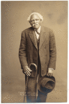 Man in suit, with hat and cane, ca. 1912