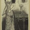 Woman in an evening gown standing indoors, England, 1890s