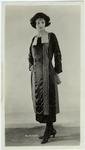 Woman in dark long-sleeved dress with vertical accents, ca. 1921
