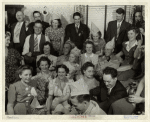 Group of smiling civilians and military personnel at a party