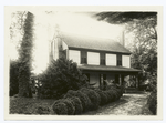View of three story home with family on front porch