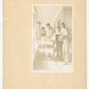 Men gathered around book cart in hall