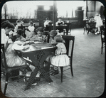 Girls doing embroidery as woman reads to them, Columbus roof