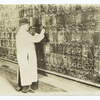 Man changing stock quotes on a chalk board