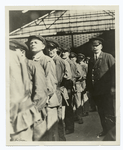 Lining up of porters before the train arrives, with an American Express interpreter "on the job" immediately behind them.