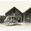 Stagecoach in front of wooden buildings