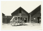 Stagecoach in front of wooden buildings
