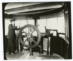 Man at the wheel of a ship