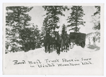 Rural mail truck stuck in snow in Uintah Mountains, Utah.