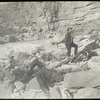 [A Noonday Rest in Marble Canyon, showing well the head of a fall. Snapshot by James Hogue, 1890. From left to right, Travers (standing), Hislop, Kane, Gibson, Ballard, Edwards, Twining (standing), Stanton, McDonald, Brown.]