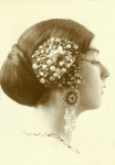 Portrait head of Ruth St. Denis in wig and East Indian jewelry.