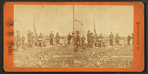 View of men in ceremonial dress firing a cannon.