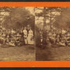 Group of men and women posing under the trees.