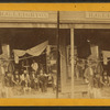 A general store with a group posed on the porch.