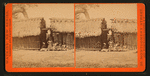 Family posing in front of thier hut.