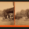 Women and children in their porch and a man standing out.