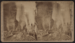 Men looking at smoking ruins after a fire