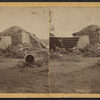 View of a collapsed barn with a haystack.