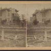 View of a damaged house with collapsed roof.]