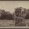 View of a house with no roof and downed trees around.