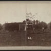 View of farmers rebuilding a haystack.