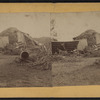 View of a collapsed barn with a haystack.