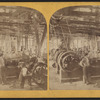 Men in an unidentified mill showing belt driven equipment.