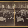 Interior of a large hall showing booths set up for a fair.