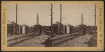 View of a railroad yard showing switches and tower.