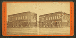 View of a business block with a druggist and a hardware store.