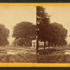 View of a muddy street with a puddle after rain.