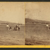 A group of Hawaiians on the beach, ships and town in the background.