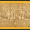 Group portrait of people in front of cottages.