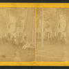 Group portrait of people in front of cottages.