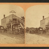 Workers and buggies in front of buggy shop.