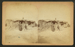 Three people in front of a sod house.